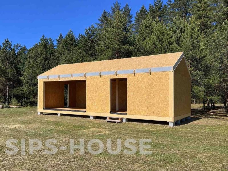 SIPS house under construction showing assembled SIP wall panels and timber roof structure sips-house.com